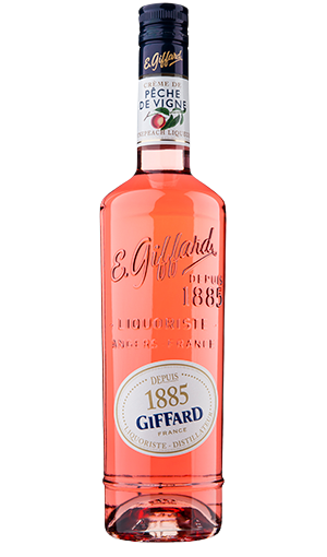 Bottle of Giffard Creme de Peche de Vigne 750 ML with ripe vine peaches and a cocktail glass