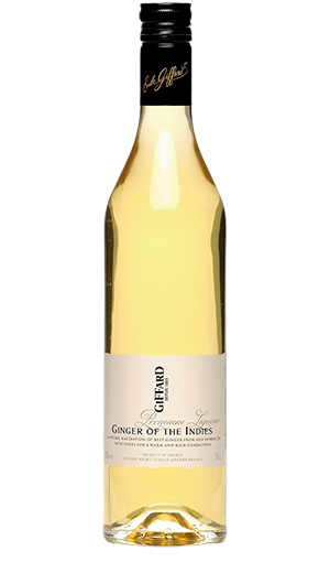 Bottle of Giffard Ginger of the Indies 750 ML with fresh ginger roots and a cocktail glass